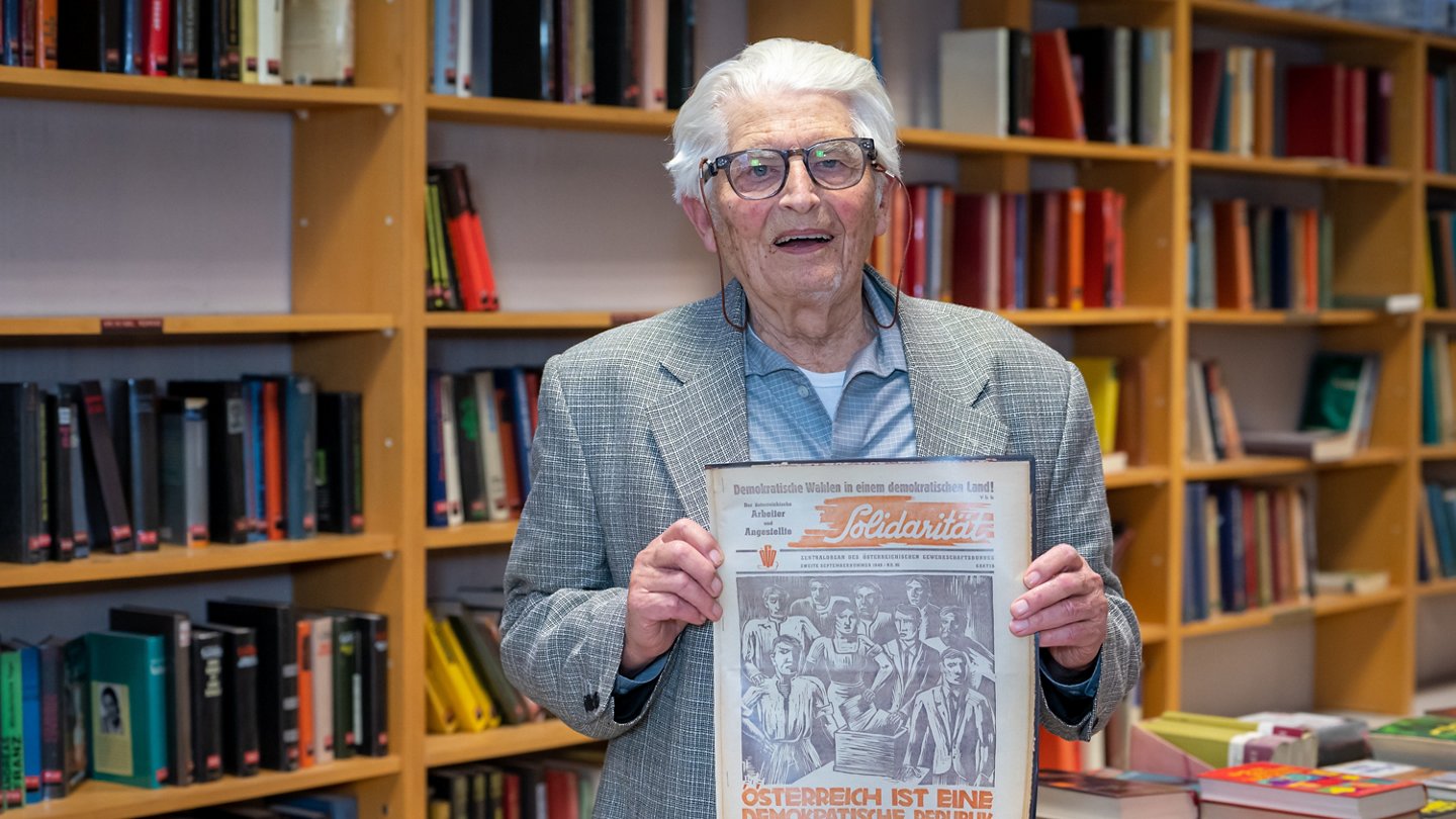 Alfred Heiden in der Gewerkschaftsbibliothek in Weiz, mit einer Ausgabe der Solidarität aus dem Jahr 1949, dem Jahr, als er Gewerkschaftsmitglied wurde, 2023 