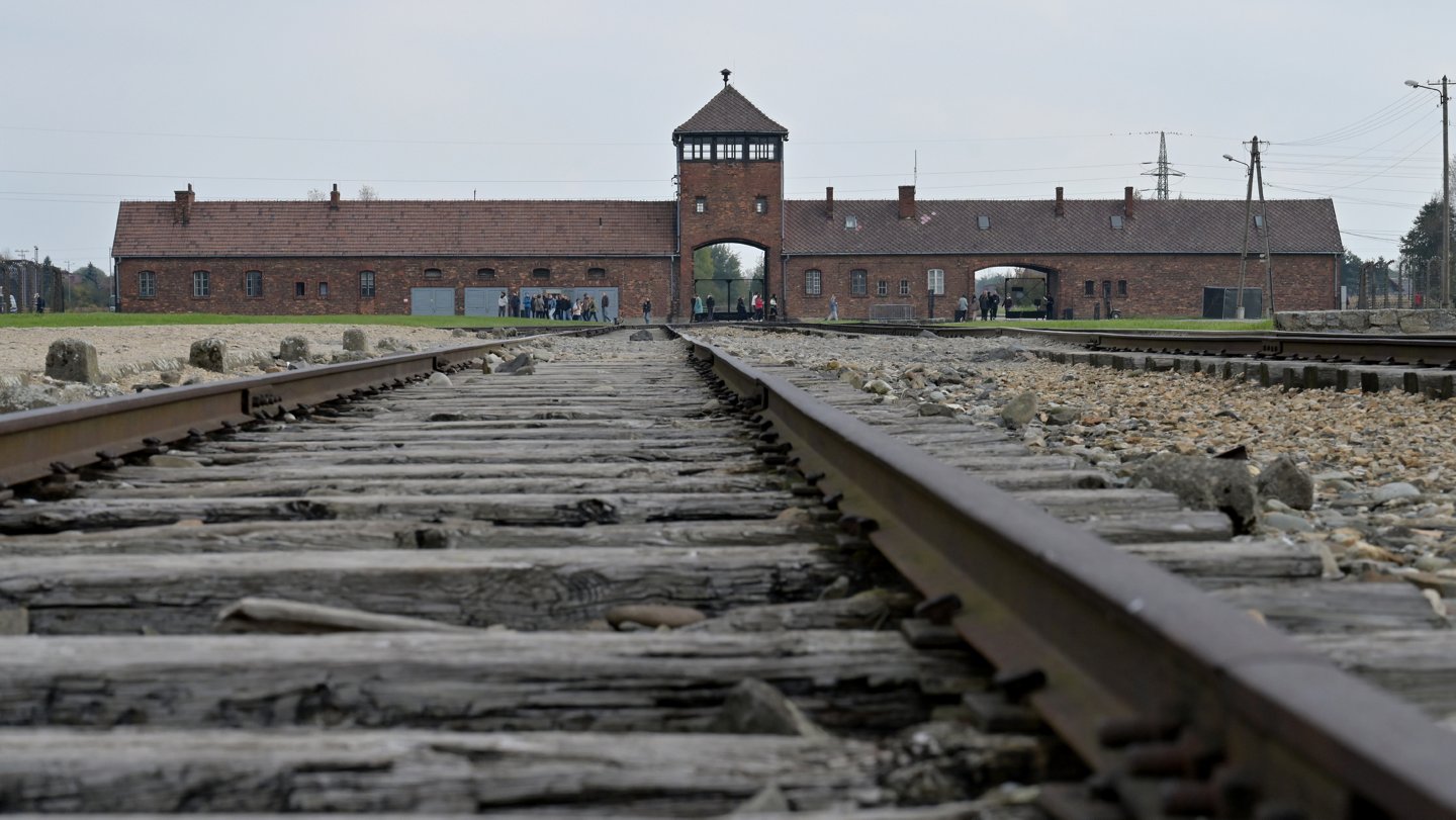 Gleise vor dem ehemaligen KZ Auschwitz Birkenau mit Blick auf den Eingang
