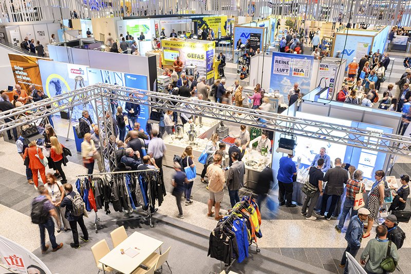 Stände bei einer Ausstellung die von vielen Personen besucht werden