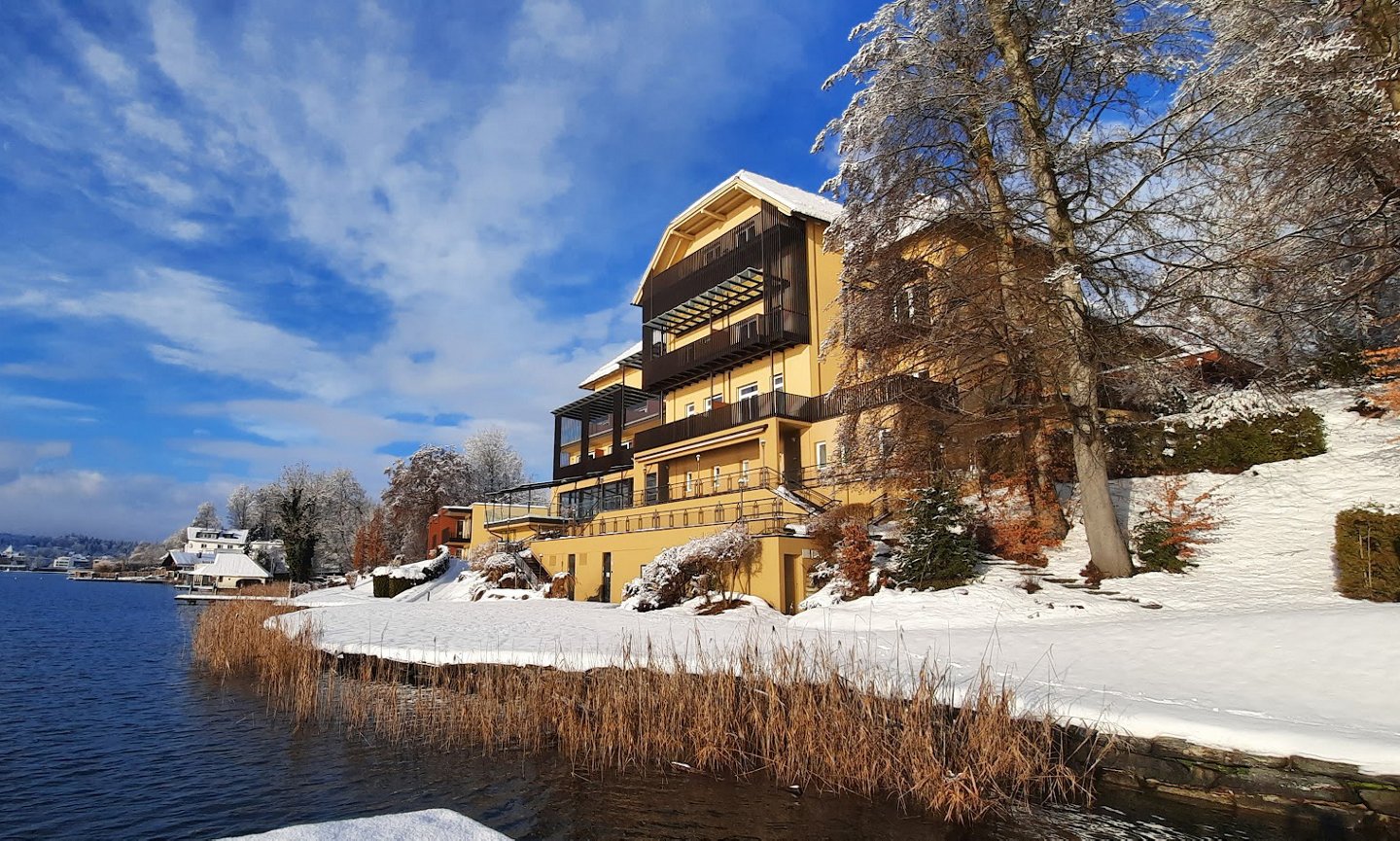 Haupthaus in Velden am Wörthersee verschneit mit blauem Himmel