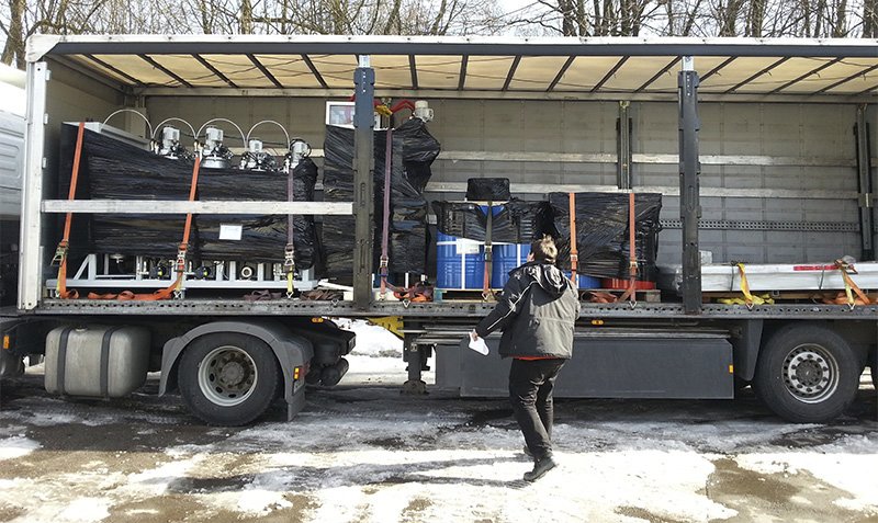 Eine Person prüft das Ladegut auf einem Sattelschlepper