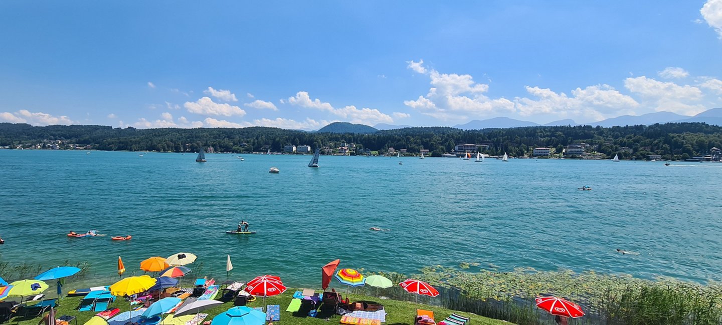 Liegewiese am Wörthersee mit bunten Sonnenschirmen