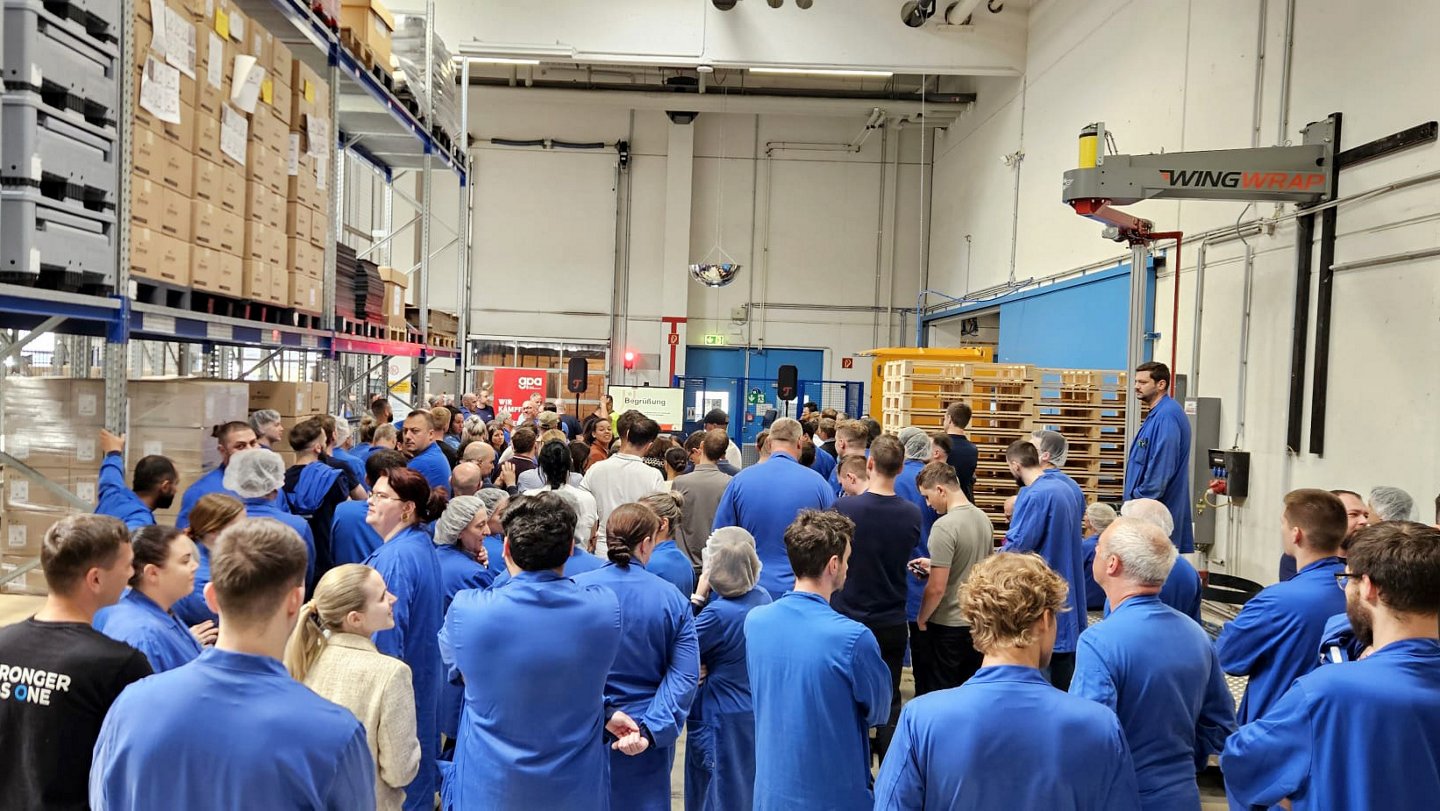 Teilnehmer:innen der Versammlung in einer Lagerhalle