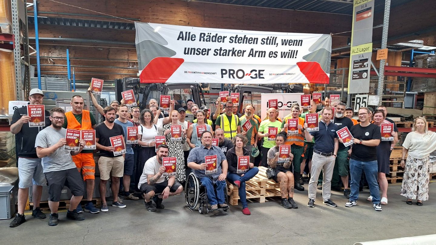Gruppenfoto der Teilnehmer:innen mit Schildern, darüber ein Transparent "Alle räder stehen still, wenn unser starker Arm es will!"