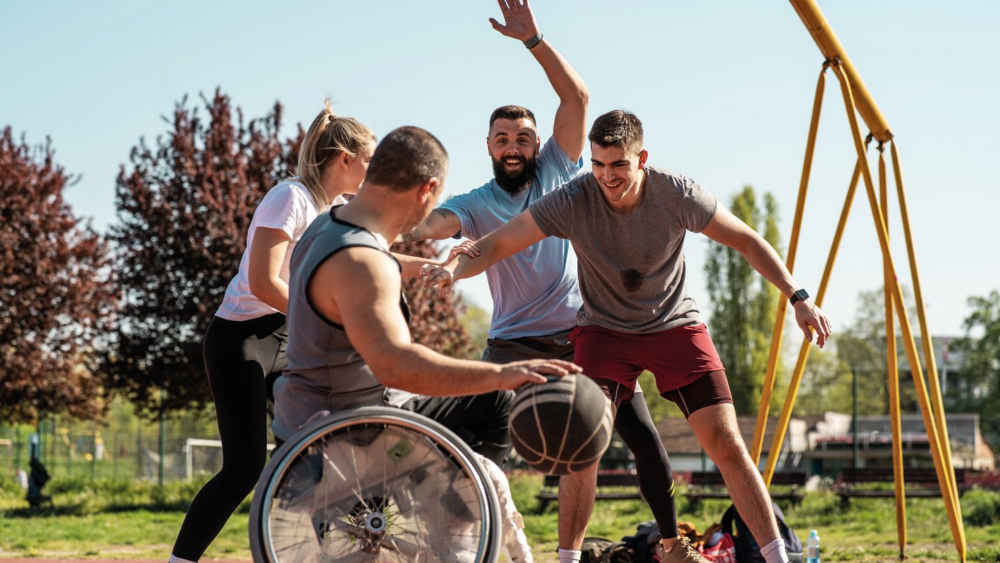 Frauen und Männer spielen Basketball