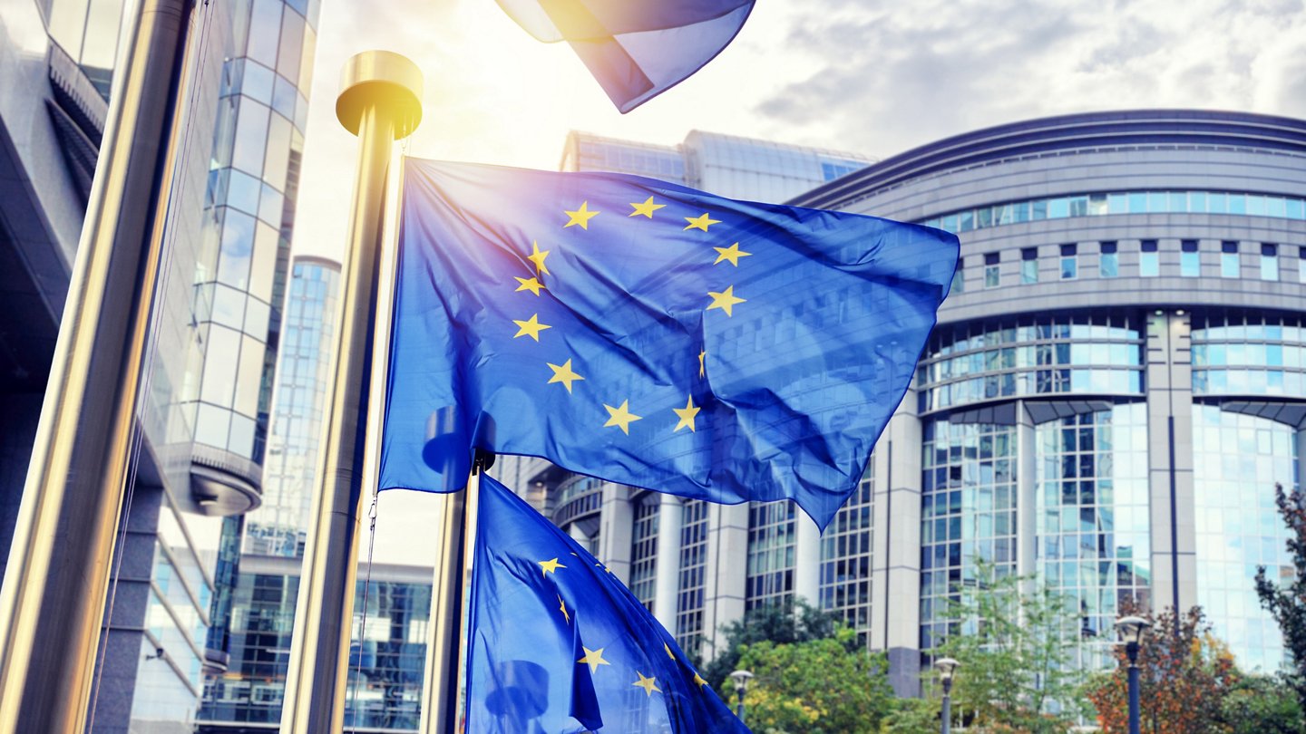 EU flags waving in front of European Parliament building. Brussels, Belgium