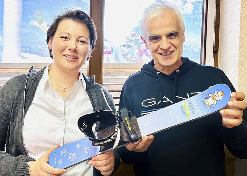 Zwei Personen präsentieren einen 3D-gedruckten Kinderski.