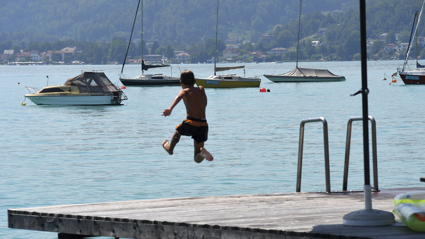 Kind springt vom Steg in den Wörthersee