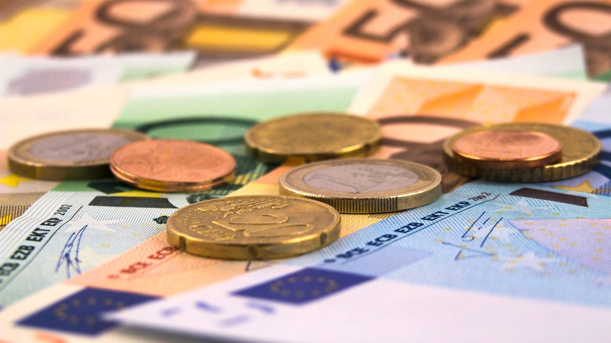 Euro- und Centmünzen liegen auf einigen Euroscheinen