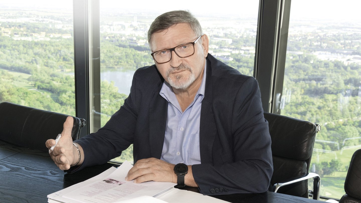 Walter Pfoser in seinem Büro, im Hintergrund sieht man den grünen Wienerberg Park