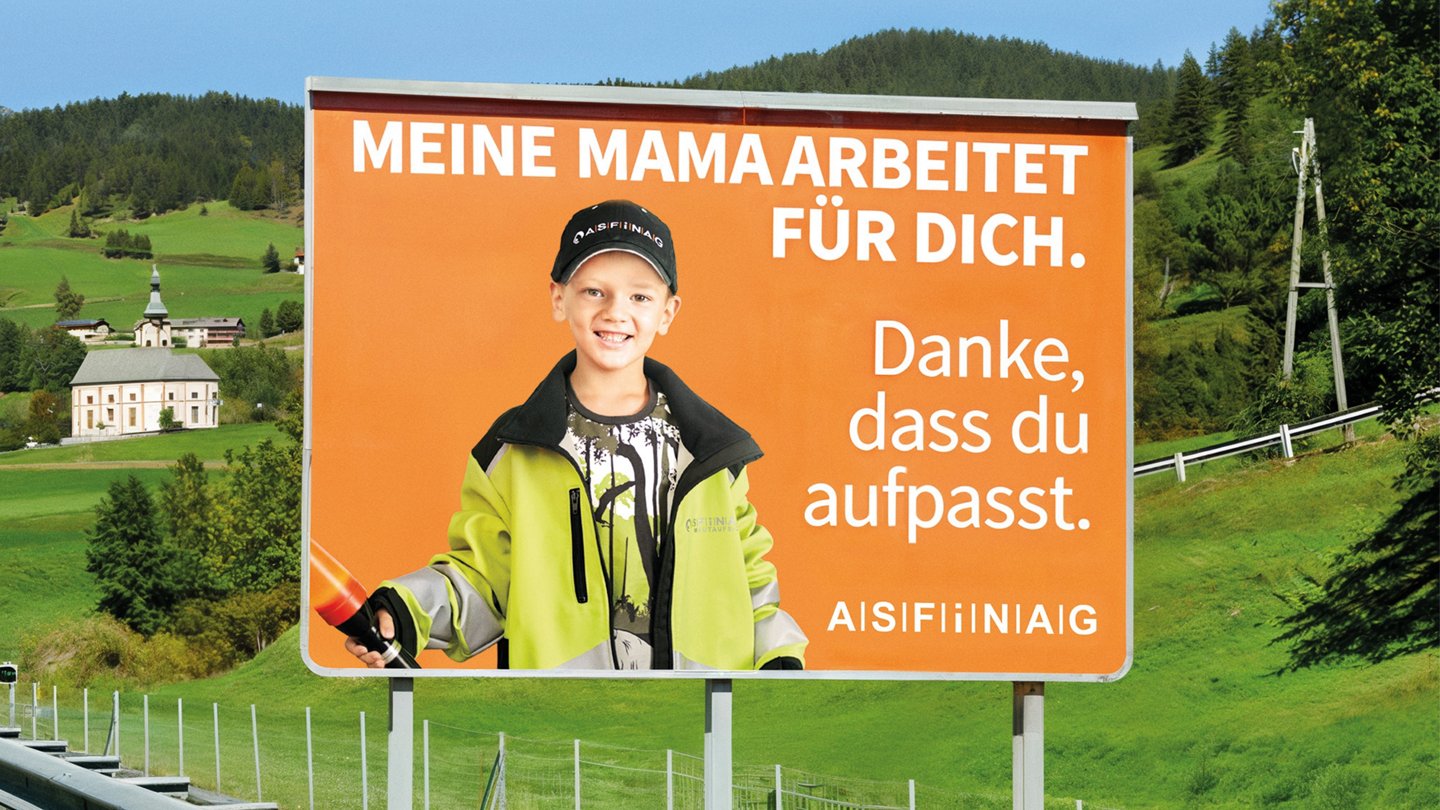 ein Plakat an einer Straße mit der Aufschrift: meine Mama arbeitet für dich. Danke, dass du aufpasst. ASFINAG, darauf ist ein Junge mit Schutzweste und einer Lampe zu sehen.