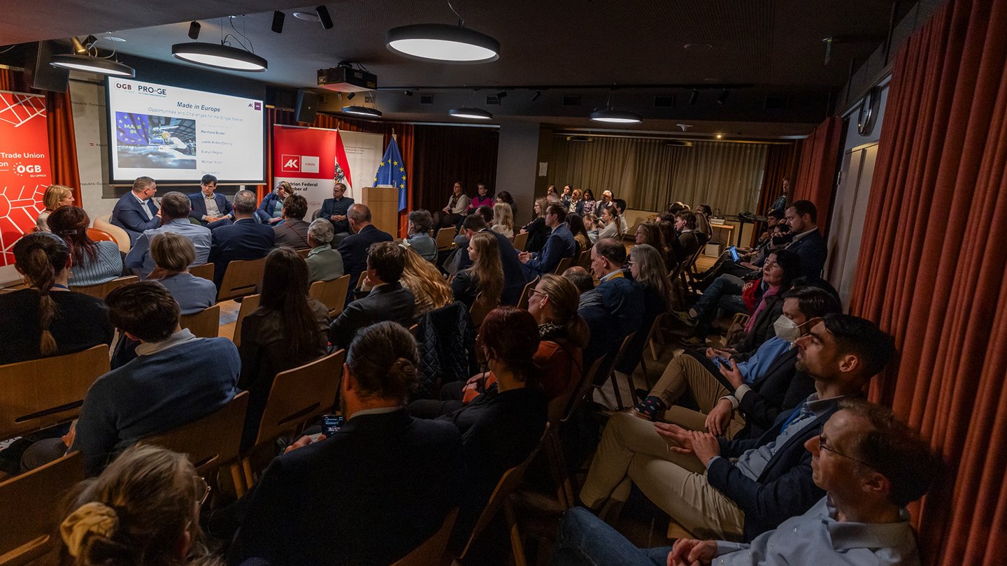 Veranstaltungsraum: Blick über das Publikum auf die Teilnehmer:innen der Podiumsdiskussion