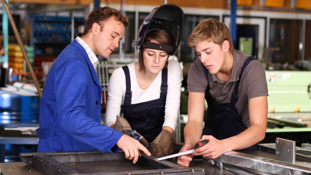 3 Personen arbeiten zusammen in einer Werkstatt