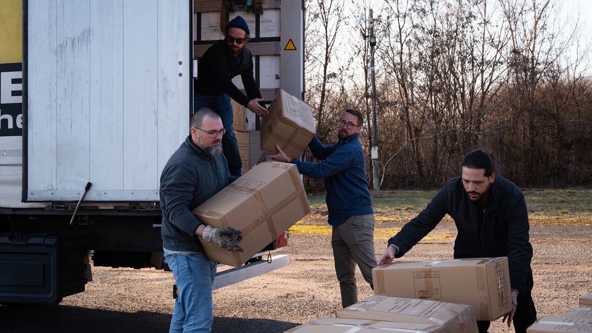 Helfer laden die Hilfsgüter aus dem LKW an der ukrainischen Grenze