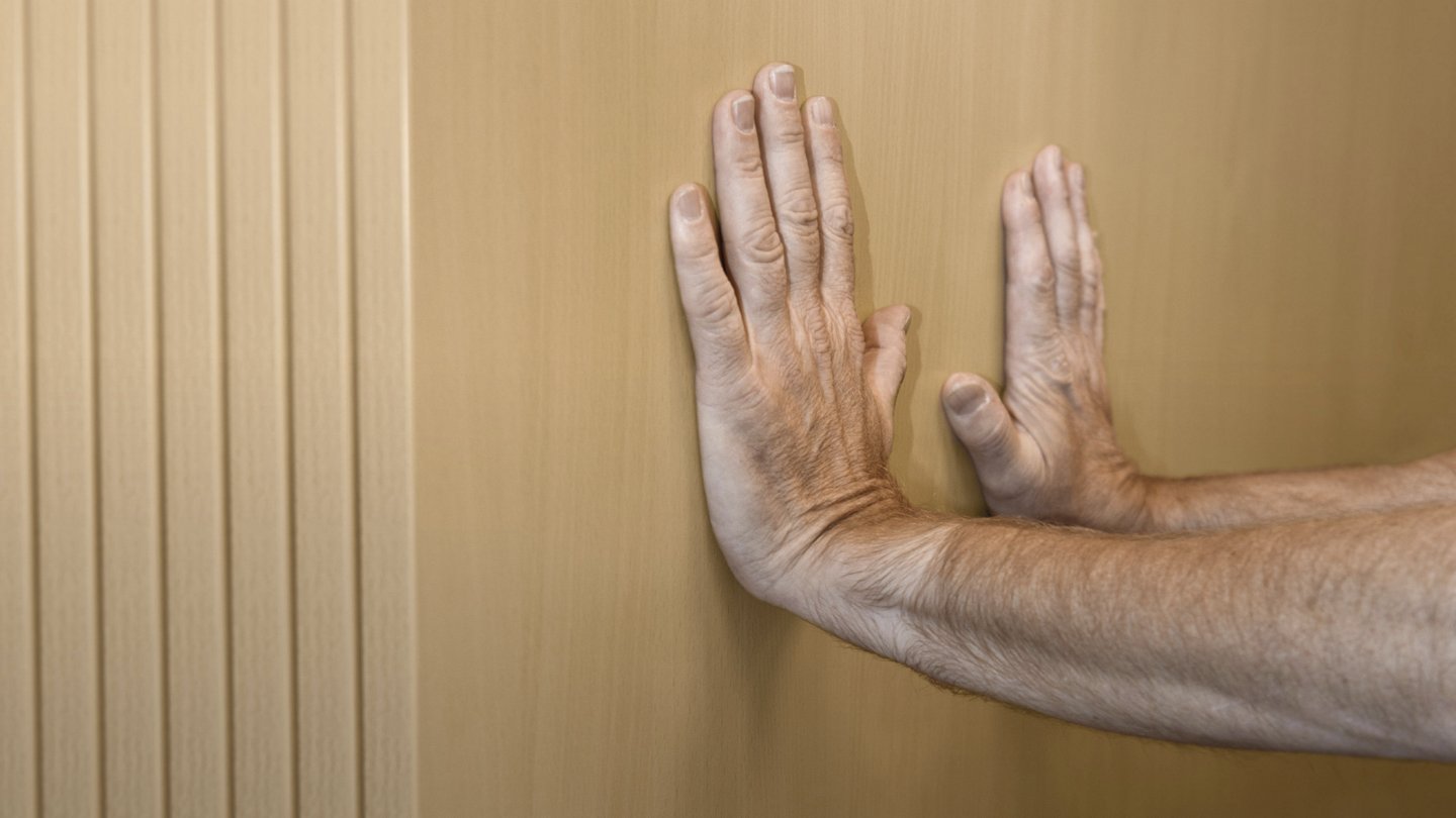 zwei Hände stemmen gegen eine Wand