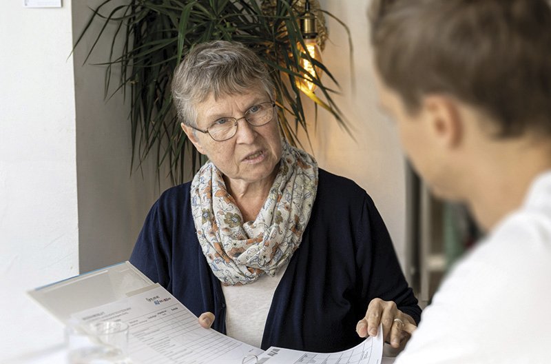 die Frau erläutert dem Mann anhand einer Checkliste etwas