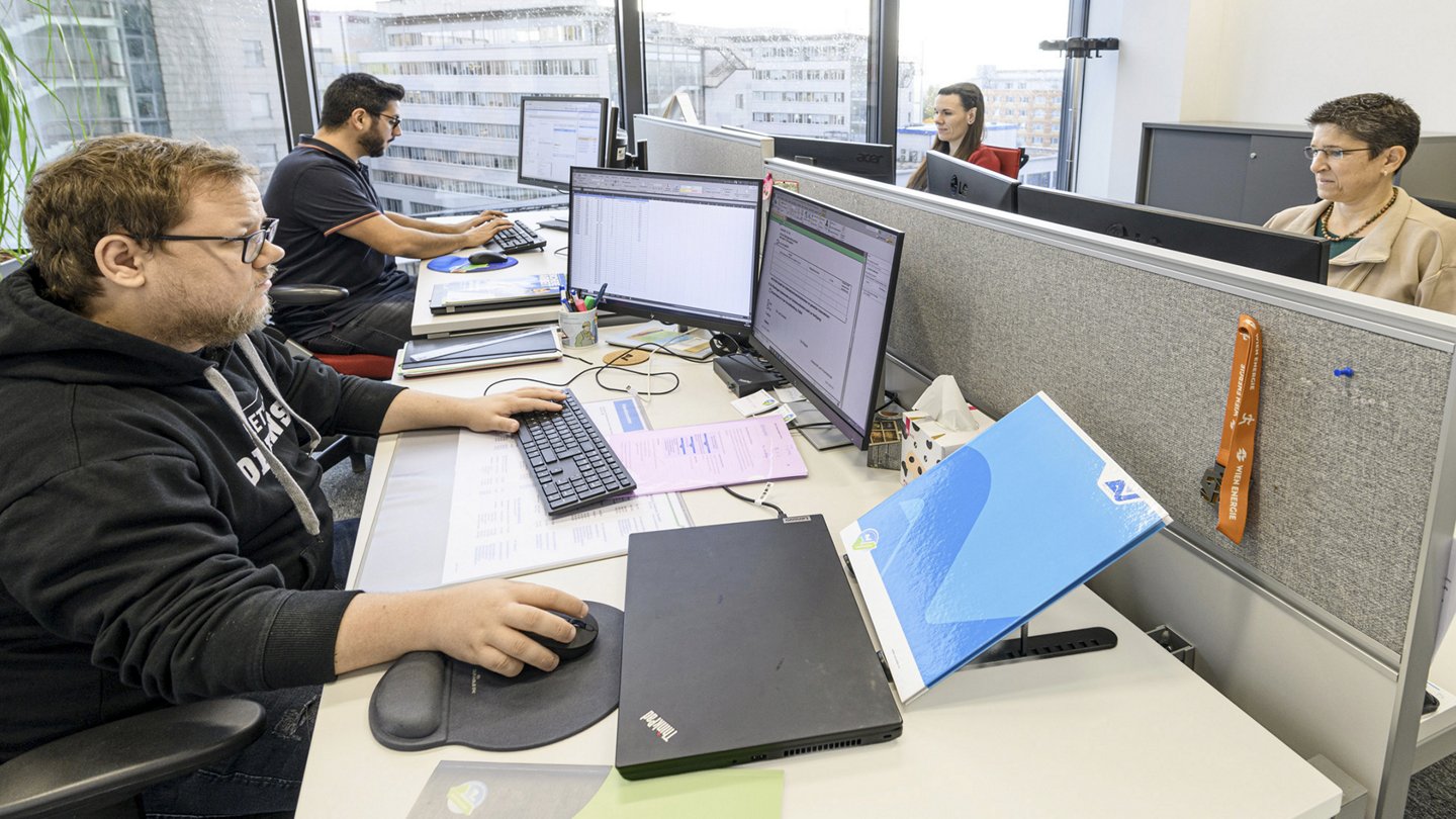 ein Büro mit Personen, die vor ihren Computern sitzen und arbeiten